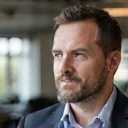 A professional portrait of a confident man, James, with a thoughtful and engaged expression.